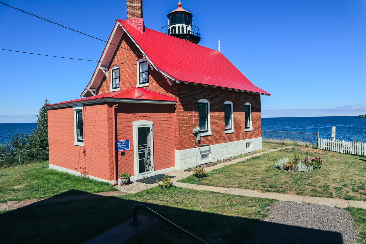 Close view of Eagle Harbor Lighthouse's red brick keeper's quarters with the white tower rising behind the roofline