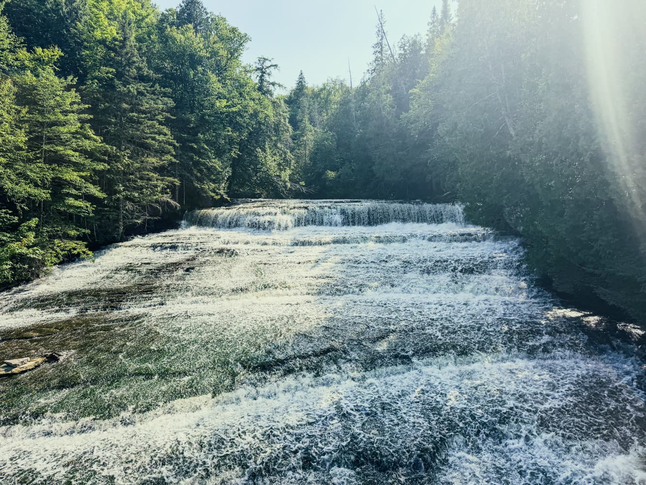Au Train Falls spreading across wide rock ledges in Michigan's Upper Peninsula, framed by summer forest