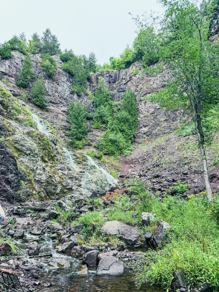 Wide view of Houghton Douglass Falls cascading down the gorge wall, seen from the bottom