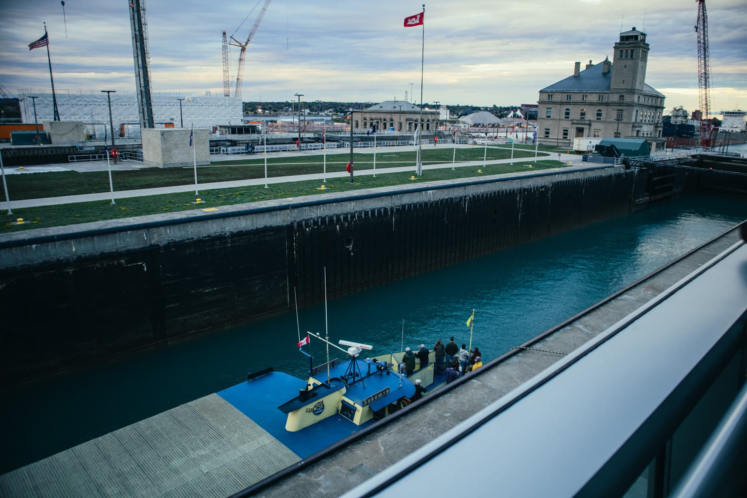 Looking down from the Soo Locks observation platform at a boat with passengers inside a lock chamber
