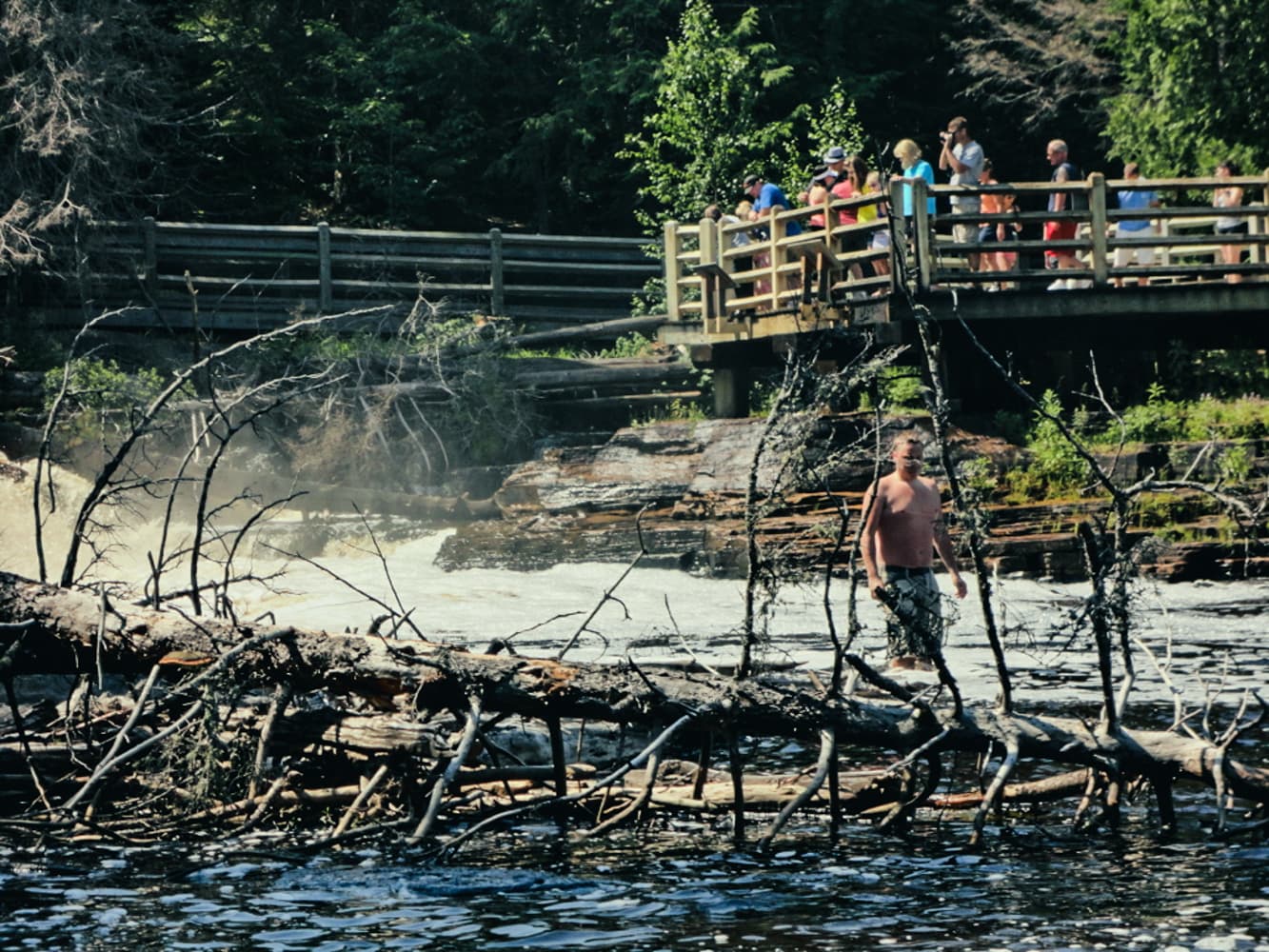 Visitors on the pedestrian bridge and viewing platform overlooking Tahquamenon Lower Falls